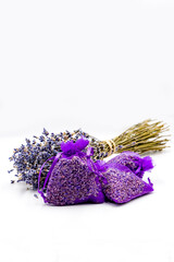 dried lavender flowers in purple gift bags with lavender bouquet on white background