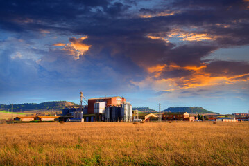 Beautiful landscape scenery with sunset, Agricultural Silos - Building Exterior, Storage and drying of grains, wheat, corn, soy, sunflower, Europe Spain