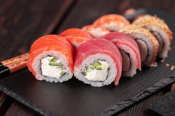 Rolls set with fish salmon and shrimp and tuna maguro eel sushi with chopsticks close-up - asian food and japanese cuisine concept