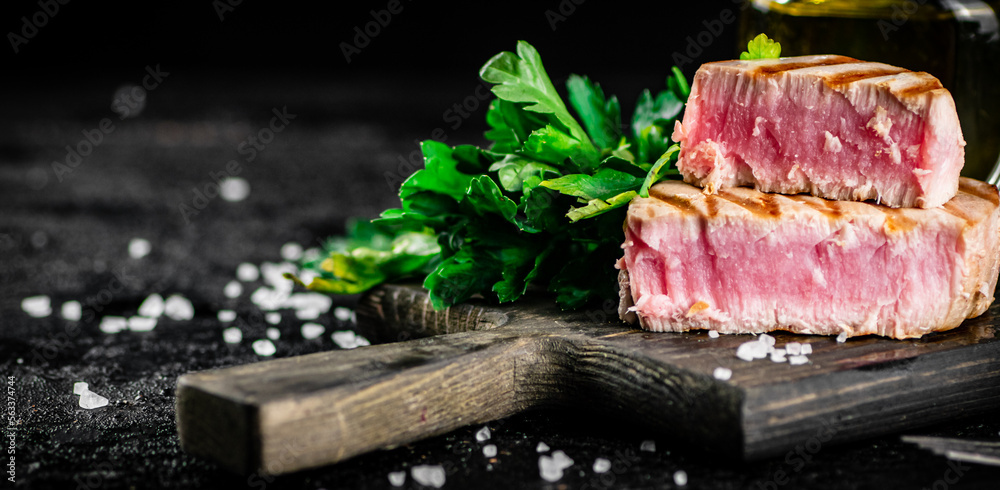 Canvas Prints Grilled tuna steak on a parsley cutting board. 