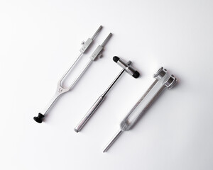 tuning fork C 128 on a white background with gradation and neurological hammer