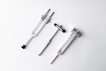 tuning fork C 128 on a white background with gradation and neurological hammer
