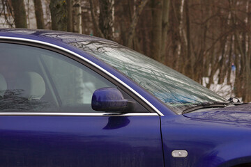 Obraz premium Fragment of a blue car in winter