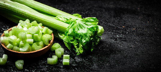 Pieces of celery in a wooden plate on the table.
