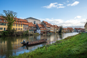Fototapeta na wymiar Regnitz River riverbank with small boats and old houses - Bamberg, Bavaria, Germany