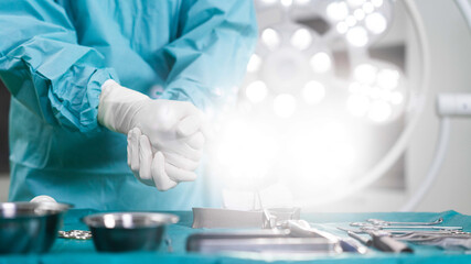 Surgeon preparing medical equipment with operating lamp