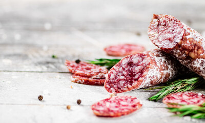 Pieces of salami sausage with sprigs of rosemary. 