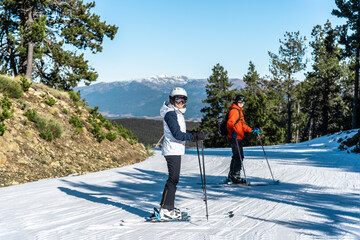 Two people standing on a ski slope.