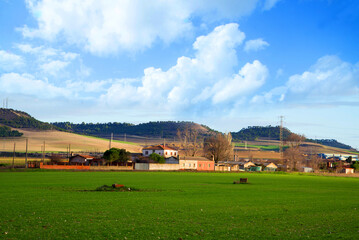 Beautiful landscape scenery with meadow and small buildings under blue sky, Europe Spain