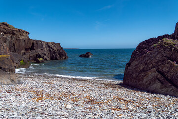 A beach on the coast of the Atlantic Ocean on a sunny day. Picturesque rocky coast. Seascape, rock formation on sea shore. © Oleksii