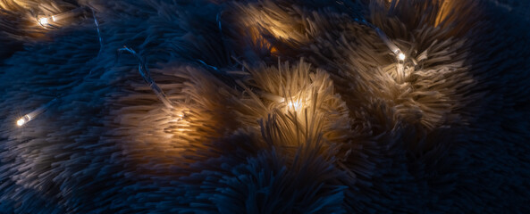 Soft gentle wool of warm bedspread close-up with diode electric small lamps on it