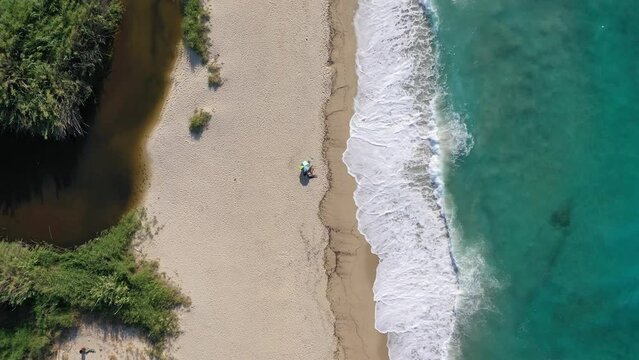 Aerial drone video of famous bay and organised sandy beach of Livadi Armenistis, popular for surfing sports, Ikaria island, Northeast Aegean, Greece