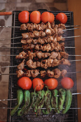fried tomatoes peppers and garlic on the grill. Barbecue. Shish kebab and grilled peppers on hot grill. Turkish style meat shish kebab on barbecue
