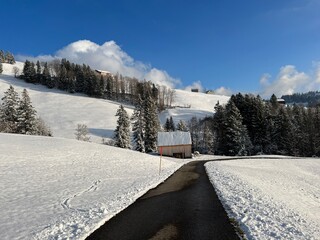 Fototapeta na wymiar Winter snow idyll along the rural alpine road above the Lake Walen or Lake Walenstadt (Walensee) and in the Swiss Alps, Amden - Canton of St. Gallen, Switzerland (Schweiz)