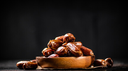 Full wooden plate with dates on the table. 
