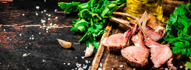 Rack of grilled lamb on a wooden cutting board with parsley. 