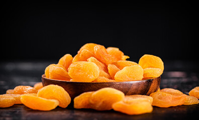 Full wooden plate with dried apricots. 