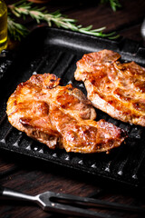 Grilled pork steak in a frying pan. 