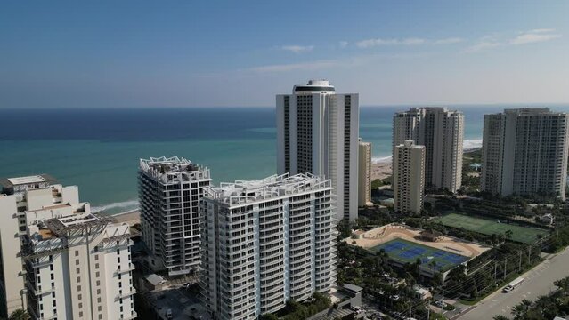 The footage provides a bird's-eye view of the building, showcasing its architecture, design, and location. The video highlights the building's location, the views of the ocean and the beach.