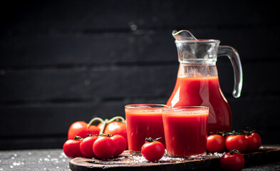 Glasses of tomato juice on a cutting board. 