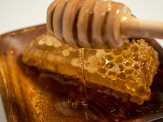 With honeycombs and a wooden spoon for honey in a wooden cup. Honeycombs and honey.