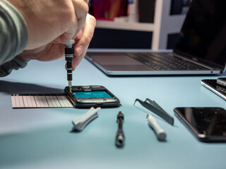A technician repairs a smartphone in a laboratory with copy space. concept of computer hardware, mobile phones, electronics, repair, upgrade and technology.
