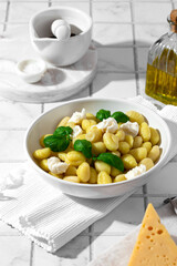 gnocchi with mozzarella and basil on a white background