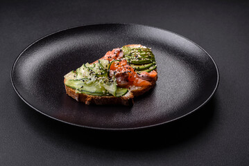 Fresh tasty sandwich with salmon, avocado and sesame and flax seeds