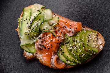 Fresh tasty sandwich with salmon, avocado and sesame and flax seeds