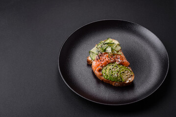 Fresh tasty sandwich with salmon, avocado and sesame and flax seeds