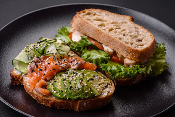 Fresh tasty sandwich with salmon, avocado and sesame and flax seeds
