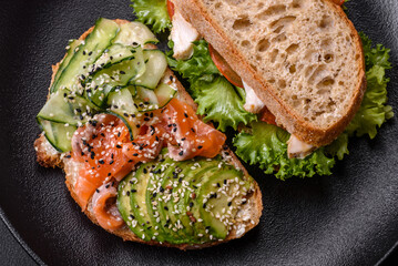 Fresh tasty sandwich with salmon, avocado and sesame and flax seeds