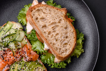Fresh tasty sandwich with salmon, avocado and sesame and flax seeds