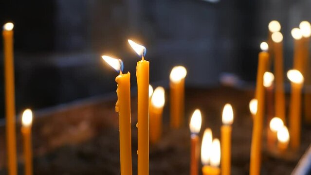 Many church candles are lit in the temple at the Christmas service. The fire of many candles in the church. The concept of religion and traditional religious holidays