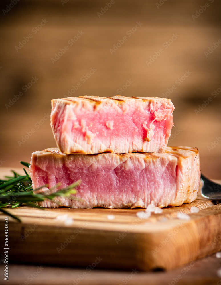 Sticker a piece of grilled tuna on a cutting board.