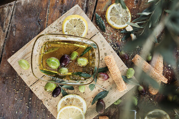 Various olives flavored with spices in cup and glass jar. Green olives, black olives. Front and top shot on wooden floor