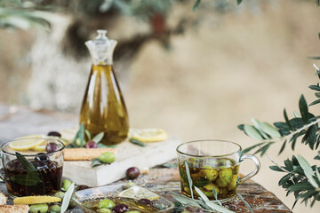 Various olives flavored with spices in cup and glass jar. Green olives, black olives. Front and top shot on wooden floor
