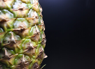 Ripe pineapple fruit close up isolated on a black background
