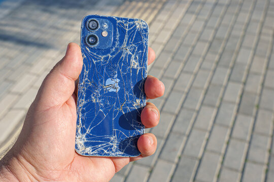 Alanya, Antalya, Turkey - Jan 19 2023, broken Apple iPhone in hand on the background of the sidewalk