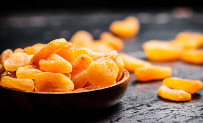 Delicious dried apricots in a wooden plate. 