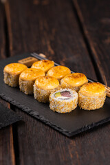 Sushi roll with tuna, avocado and tobiko caviar served on black board close-up - Japanese asian food