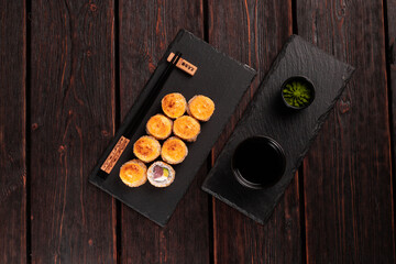 Sushi roll with tuna, avocado and tobiko caviar served on black board top view - Japanese asian food