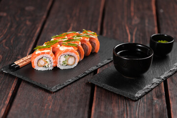 Sushi roll philadelphia with crab and cucumber and cream cheese, caviar on black background close-up. Sushi menu. Japanese food concept