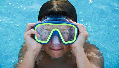 Naklejka premium Little boy wearing an Underwater mask in swimming pool ..