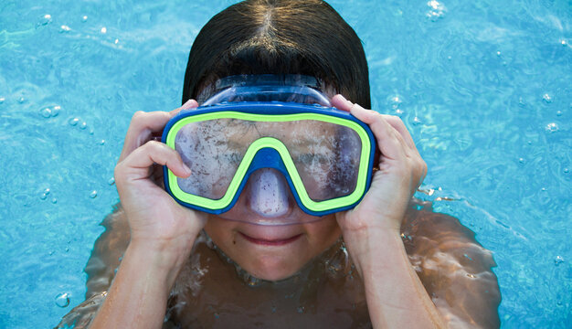 Little boy wearing an Underwater mask in swimming pool ..