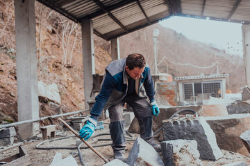 A stone pierces a factory worker. Heavy stone processing industry