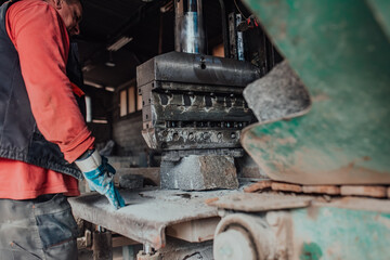 A worker in heavy industry breaks stone blocks using large machines. Granite and stone processing industry.
