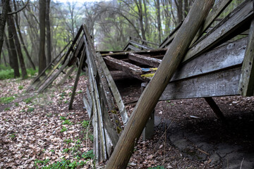 Broken railings of a wooden bridge. Bridge in the middle of the spring forest. Abandoned Old Wooden Structure