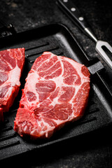 Raw pork steak on a grill pan. 