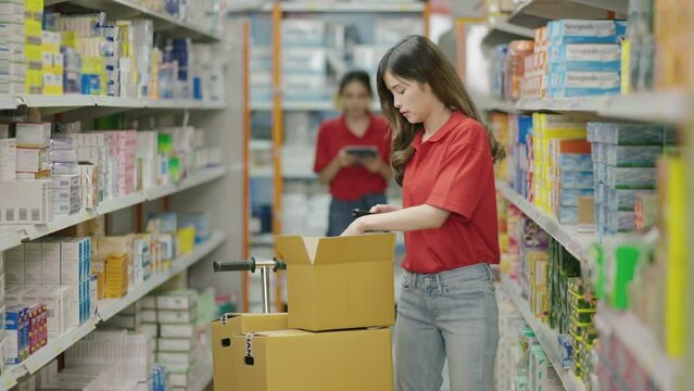Asian female retail store clerk sorting products on shelves
